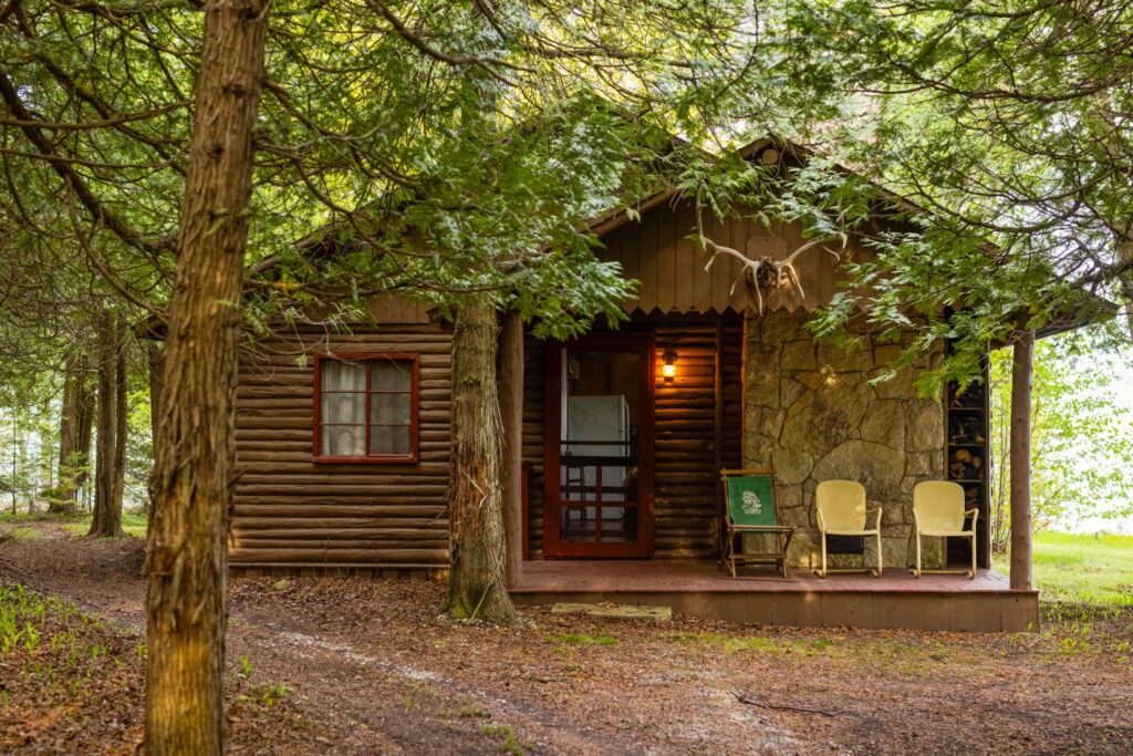 One of South Pipe Island's rustic guest cabins surrounded by mature trees on the private island in northern Lake Huron.